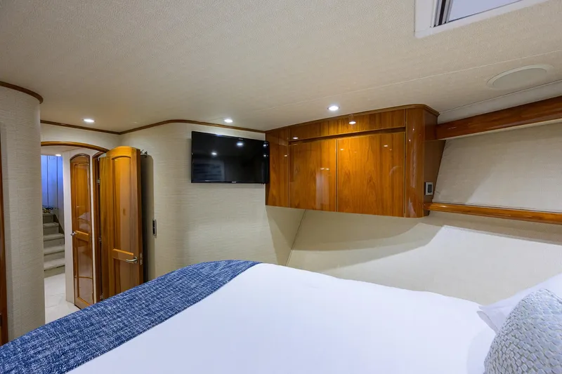 Yacht Photos Pics Luxurious cabin interior of 2015 Viking 62 Convertible yacht with wood finishes and TV.
