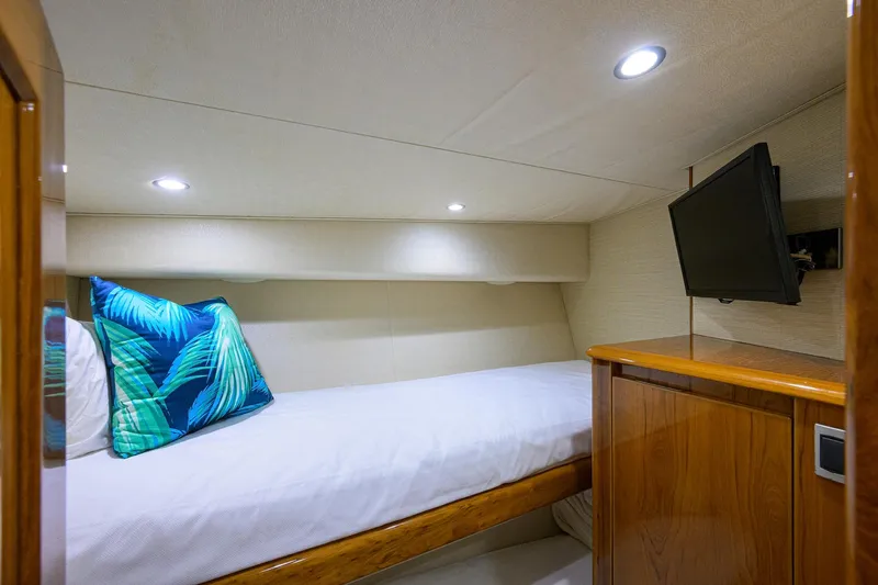  Yacht Photos Pics 2015 Viking 62 Convertible yacht cabin with bed, TV, and tropical pillow.