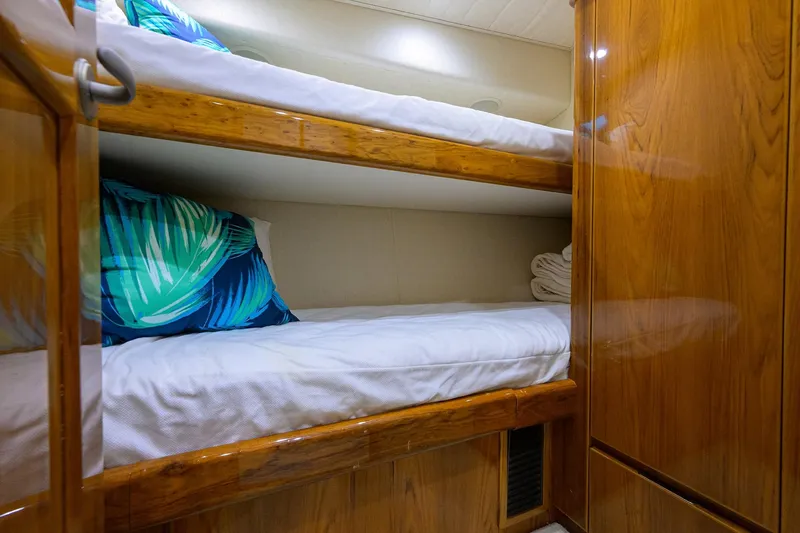 Yacht Photos Pics Bunk beds in 2015 Viking 62 Convertible yacht cabin with wooden finish and tropical pillows.