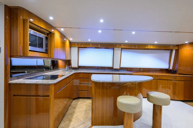  Yacht Photos Pics Luxurious kitchen interior of 2015 Viking 62 Convertible yacht with wood cabinetry and modern appliances.
