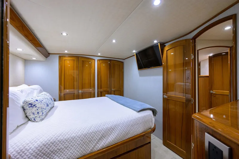  Yacht Photos Pics Luxurious bedroom interior of 2015 Viking 62 Convertible yacht with wood finishes and modern amenities.