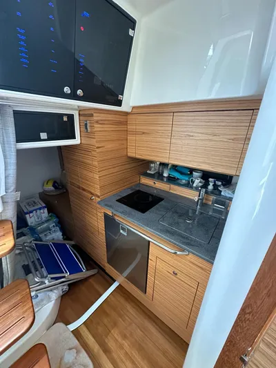  Yacht Photos Pics 2021 Boston Whaler 405 Conquest kitchen with wood cabinetry and modern appliances.