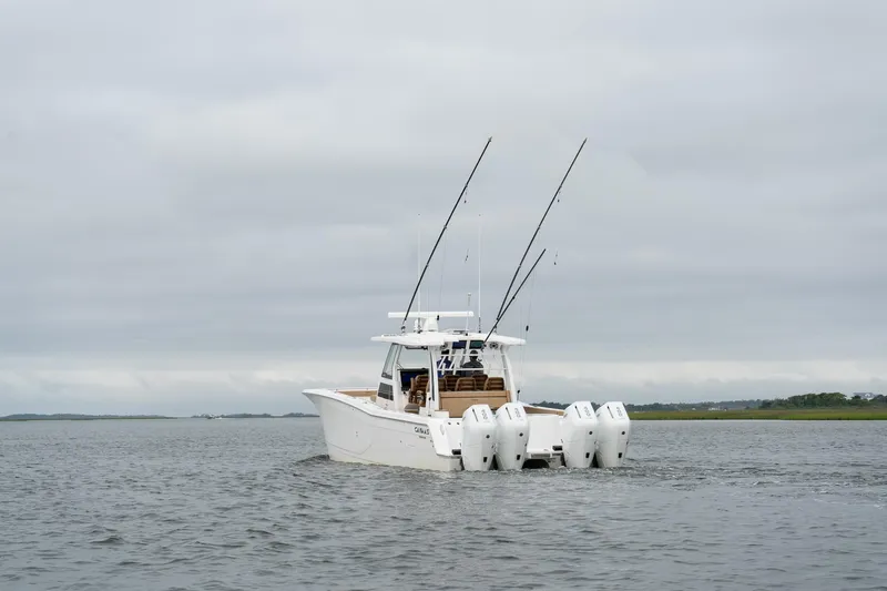  Yacht Photos Pics 2025 Caymas 44 CT boat with multiple outboard engines on a calm waterway.