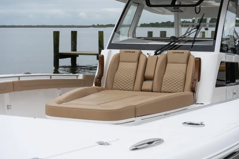  Yacht Photos Pics 2025 Caymas 44 CT boat with luxurious tan seating, docked by a serene waterfront.