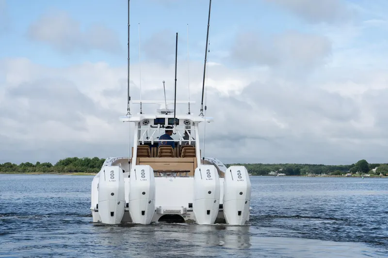  Yacht Photos Pics 2025 Caymas 44 CT boat with multiple outboard engines on a calm waterway.