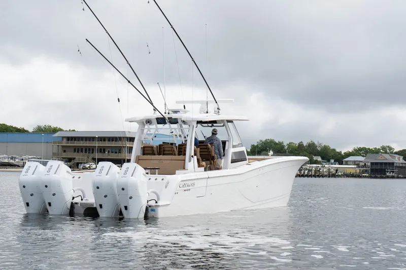  Yacht Photos Pics 2025 Caymas 44 CT boat with multiple outboard engines on a calm waterway.