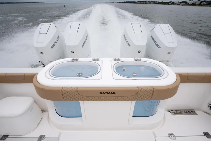  Yacht Photos Pics 2025 Caymas 44 CT boat with Mercury engines, featuring dual livewells on a calm water backdrop.