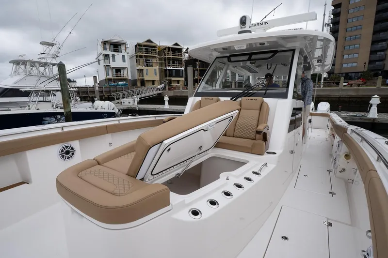  Yacht Photos Pics 2025 Caymas 44 CT boat with luxurious seating, docked in a marina.