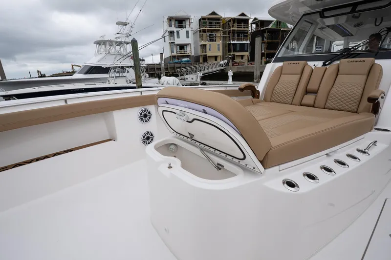  Yacht Photos Pics 2025 Caymas 44 CT boat interior with tan seating, docked near waterfront homes.