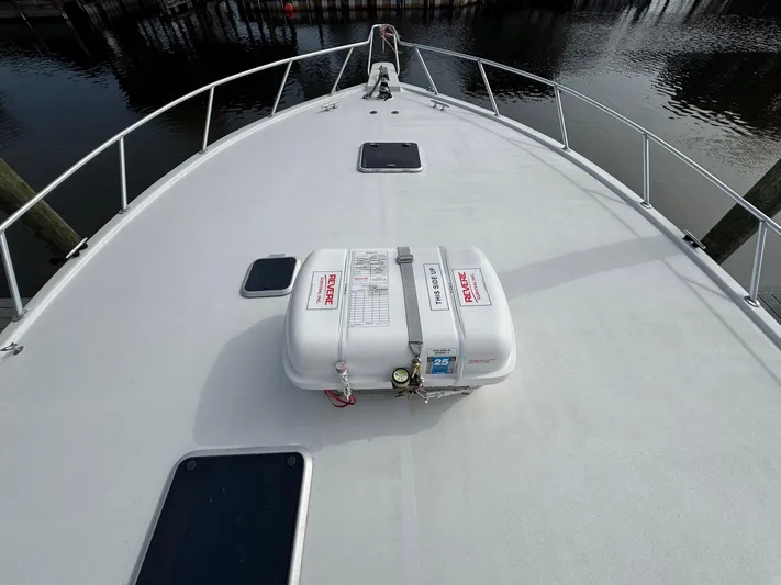 Reel Outlaw Yacht Photos Pics 1998 Richards Yachts Custom Flybridge Sportfish deck with safety equipment, docked by calm water.