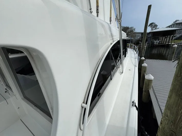 Reel Outlaw Yacht Photos Pics 1998 Richards Yachts Custom Flybridge Sportfish docked, showcasing sleek white exterior and windows.