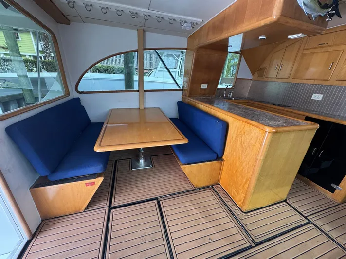 Reel Outlaw Yacht Photos Pics Interior of 1998 Richards Yachts Custom Flybridge Sportfish with wooden dining area and blue seating.