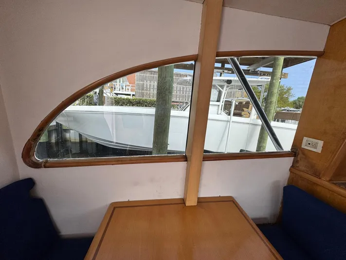 Reel Outlaw Yacht Photos Pics Interior view of 1998 Richards Yachts Custom Flybridge Sportfish, featuring a wooden table and window.