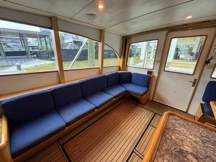 Reel Outlaw Yacht Photos Pics Interior of 1998 Richards Yachts Custom Flybridge Sportfish with blue seating and wooden flooring.