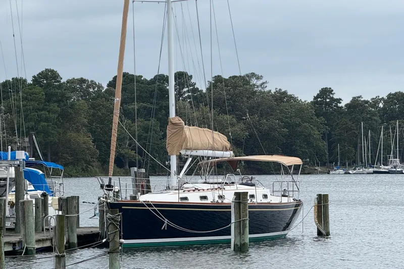 Celebration Yacht Photos Pics Sailboat Tartan 4100 (2001) docked at a marina with forested background.