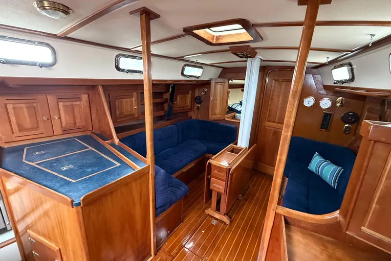 Celebration Yacht Photos Pics Interior of 2001 Tartan 4100 sailboat with wooden cabinetry and blue seating.