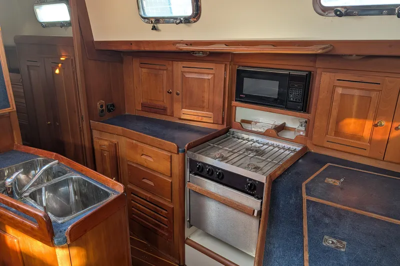 Celebration Yacht Photos Pics Wooden yacht kitchen interior with stove, microwave, and sink; Tartan 4100, 2001 model.