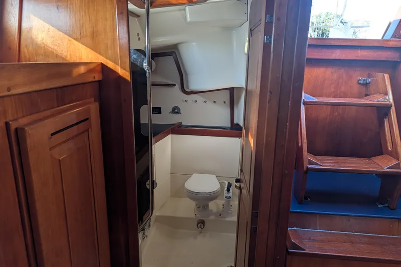 Celebration Yacht Photos Pics Interior of 2001 Tartan 4100 sailboat showing wooden cabinetry and compact bathroom.