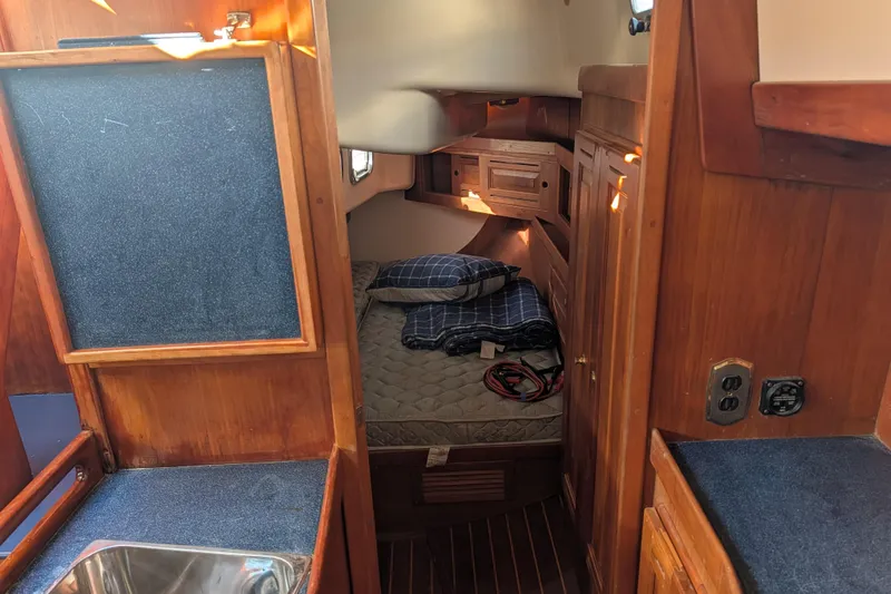 Celebration Yacht Photos Pics Cozy cabin interior of 2001 Tartan 4100 sailboat with wood finish and bedding.