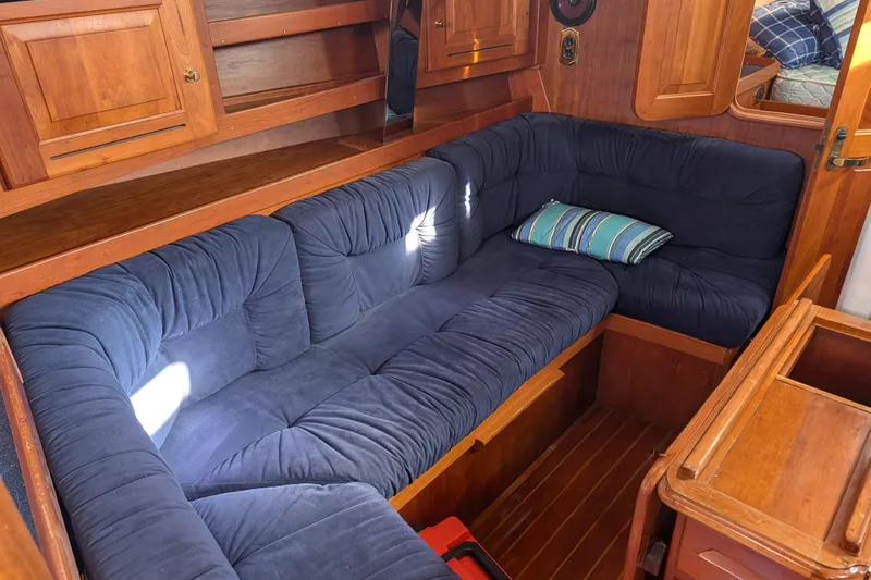 Celebration Yacht Photos Pics Cozy interior of 2001 Tartan 4100 sailboat with blue cushioned seating.