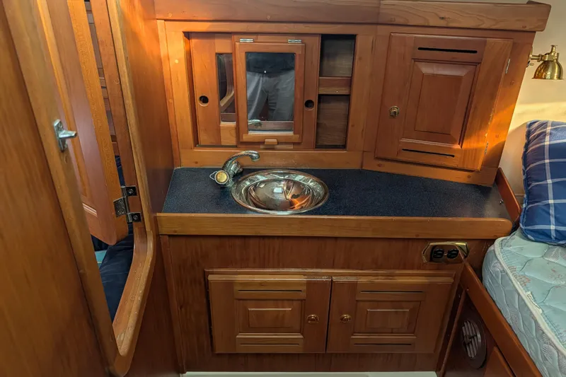 Celebration Yacht Photos Pics Wooden interior of a 2001 Tartan 4100 sailboat with sink and cabinets.
