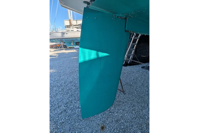 Celebration Yacht Photos Pics Tartan 4100 sailboat rudder, 2001 model, on gravel with ladder in background.