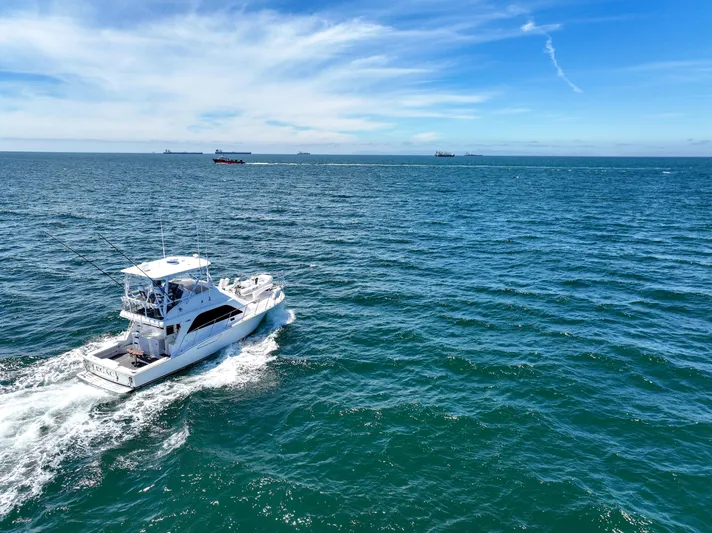 Legacy Yacht Photos Pics 2004 Cabo 40 Flybridge Convertible cruising on open ocean under clear blue sky.