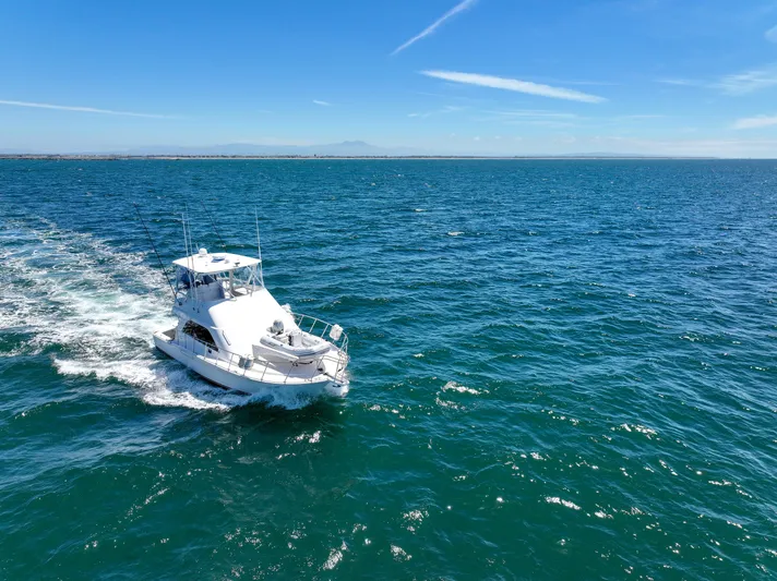 Legacy Yacht Photos Pics 2004 Cabo 40 Flybridge Convertible cruising on open ocean under clear blue sky.