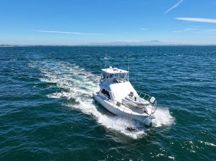 Legacy Yacht Photos Pics 2004 Cabo 40 Flybridge Convertible cruising on open sea under clear blue sky.