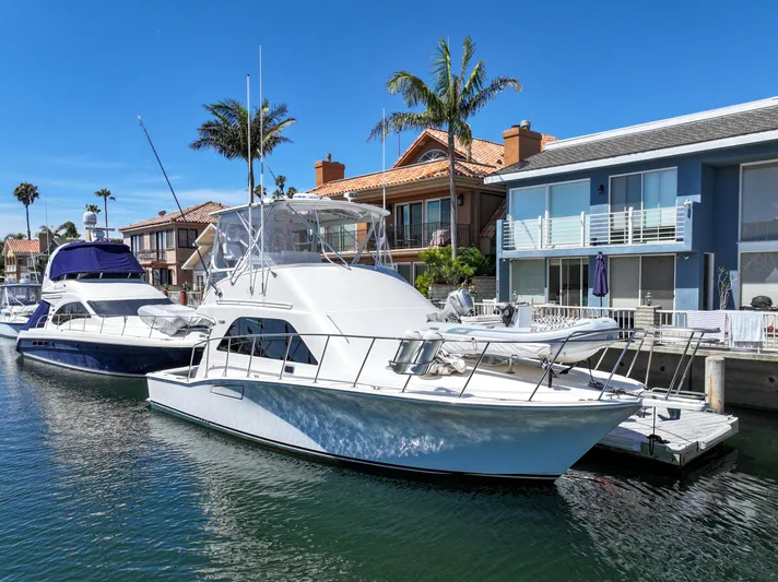 Legacy Yacht Photos Pics 2004 Cabo 40 Flybridge Convertible yacht docked near waterfront homes.