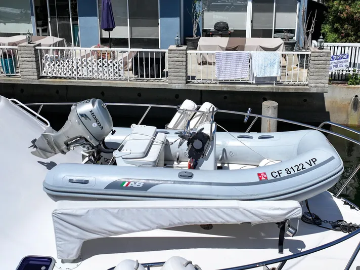 Legacy Yacht Photos Pics Inflatable boat with Honda motor on Cabo 40 Flybridge Convertible, 2004 model, docked by waterfront.