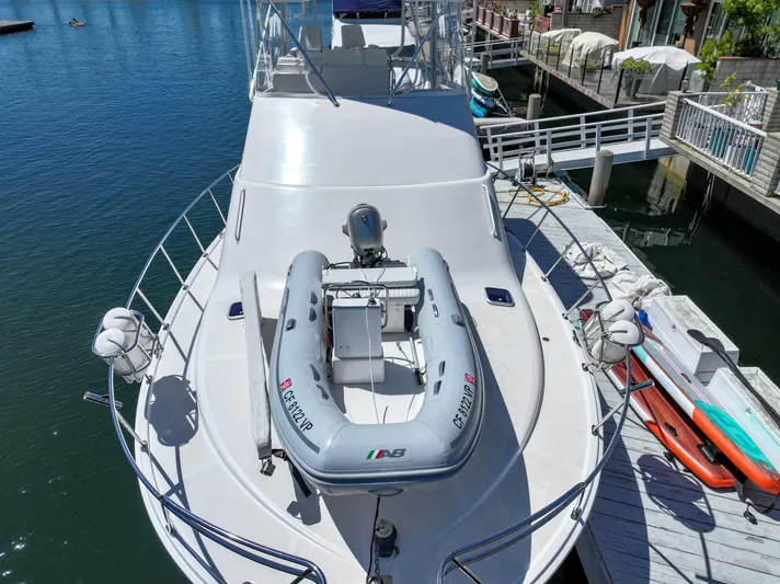 Legacy Yacht Photos Pics 2004 Cabo 40 Flybridge Convertible docked with inflatable boat on deck.