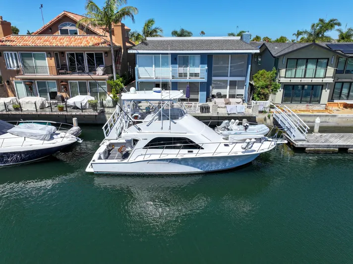Legacy Yacht Photos Pics 2004 Cabo 40 Flybridge Convertible yacht docked near waterfront homes.