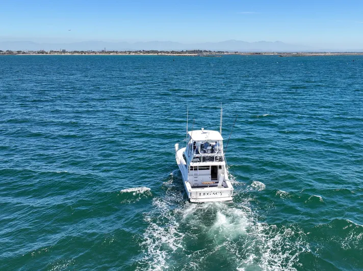 Legacy Yacht Photos Pics 2004 Cabo 40 Flybridge Convertible cruising on open sea under clear blue sky.