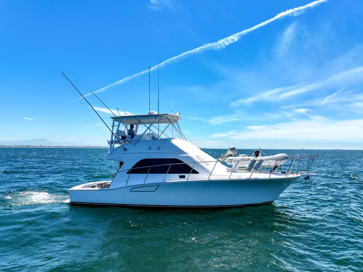 Legacy Yacht Photos Pics 2004 Cabo 40 Flybridge Convertible yacht cruising on open sea under clear blue sky.