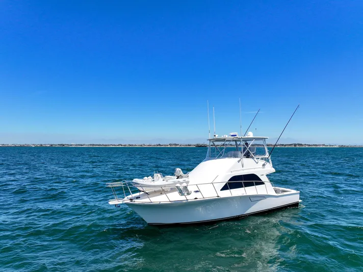 Legacy Yacht Photos Pics 2004 Cabo 40 Flybridge Convertible yacht on open sea under clear blue sky.