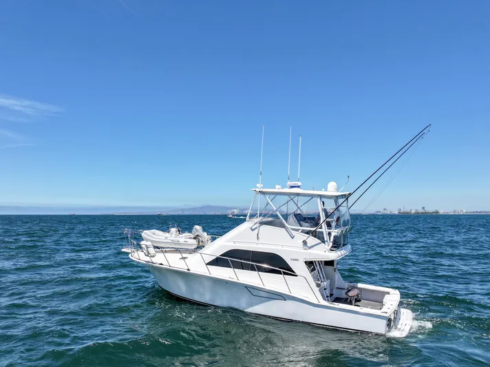 Legacy Yacht Photos Pics 2004 Cabo 40 Flybridge Convertible yacht cruising on open sea under clear blue sky.