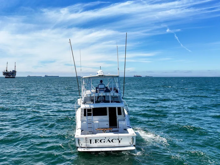 Legacy Yacht Photos Pics 2004 Cabo 40 Flybridge Convertible boat on open sea with oil rigs in background.
