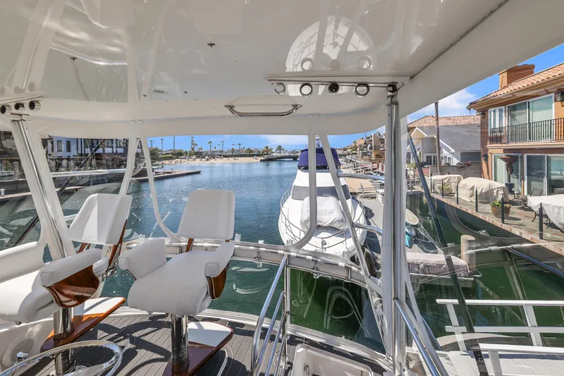 Legacy Yacht Photos Pics 2004 Cabo 40 Flybridge Convertible yacht docked in a scenic marina.