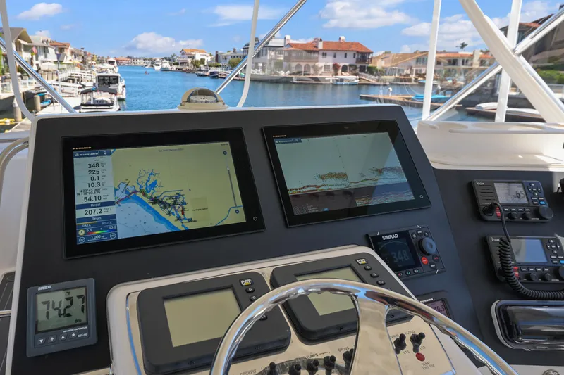 Legacy Yacht Photos Pics Helm of 2004 Cabo 40 Flybridge Convertible with navigation screens and marina view.