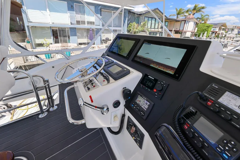 Legacy Yacht Photos Pics 2004 Cabo 40 Flybridge Convertible helm with navigation equipment and steering wheel.