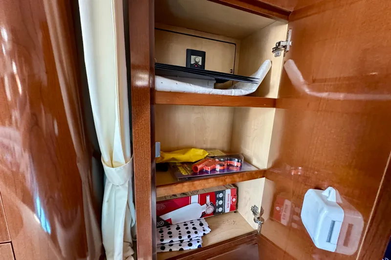 Lonie Marie Yacht Photos Pics Open cabinet in 2008 Sea Ray 340 Sundancer yacht with various items stored inside.