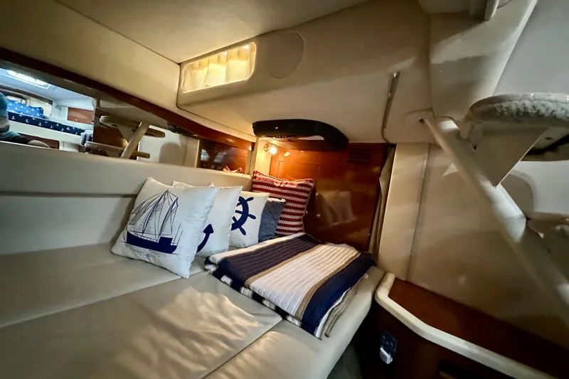 Lonie Marie Yacht Photos Pics Interior cabin of 2008 Sea Ray 340 Sundancer with nautical-themed pillows and cozy bedding.