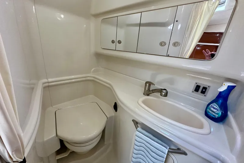 Lonie Marie Yacht Photos Pics 2008 Sea Ray 340 Sundancer bathroom with sink, toilet, mirror, and cleaning supplies.