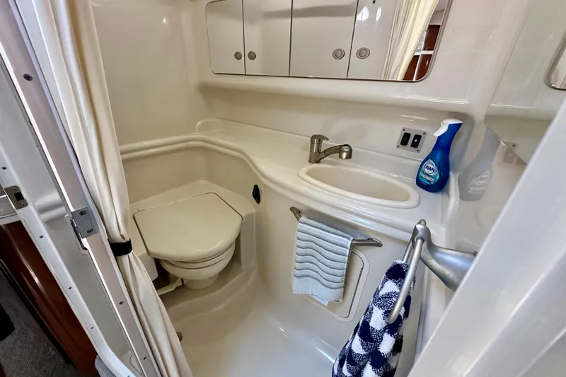 Lonie Marie Yacht Photos Pics Compact bathroom in 2008 Sea Ray 340 Sundancer yacht with sink, toilet, and storage cabinets.