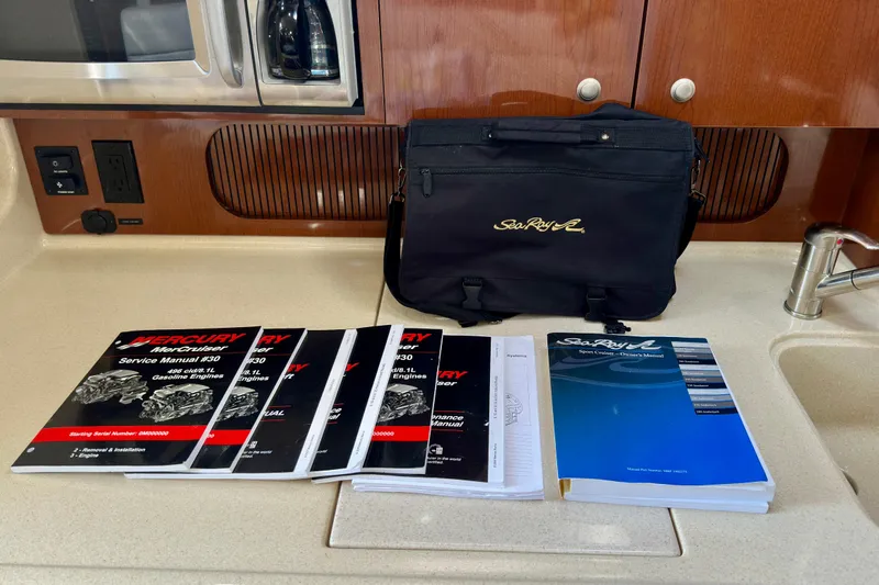 Lonie Marie Yacht Photos Pics Bag and manuals for 2008 Sea Ray 340 Sundancer on a kitchen counter.