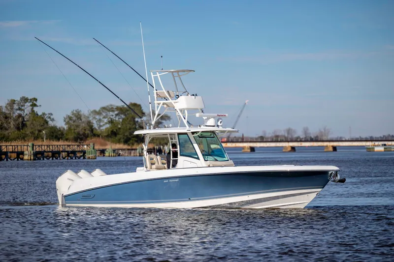  Yacht Photos Pics 2019 Boston Whaler 350 Outrage boat cruising on a calm river under a clear blue sky.