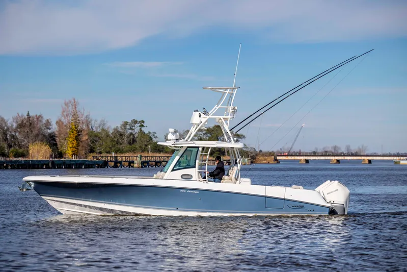  Yacht Photos Pics 2019 Boston Whaler 350 Outrage boat cruising on a calm river with scenic background.