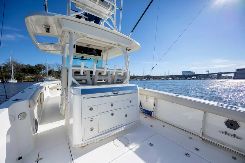  Yacht Photos Pics 2019 Boston Whaler 350 Outrage boat interior with seating and storage, docked by a sunny waterfront.
