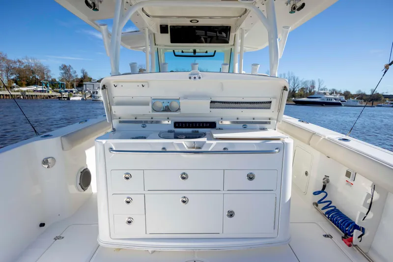  Yacht Photos Pics 2019 Boston Whaler 350 Outrage boat interior with storage and equipment, docked by the water.